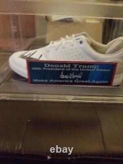 Le président DONALD TRUMP a signé un étui et une plaque d'identification JSA pour des chaussures de golf automatiques.